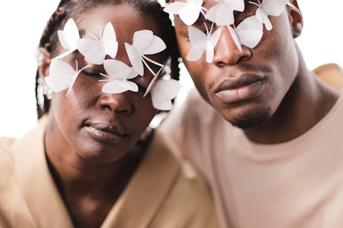 Close-Up Shot of Man and Woman with White Butterflies on Their Faces
