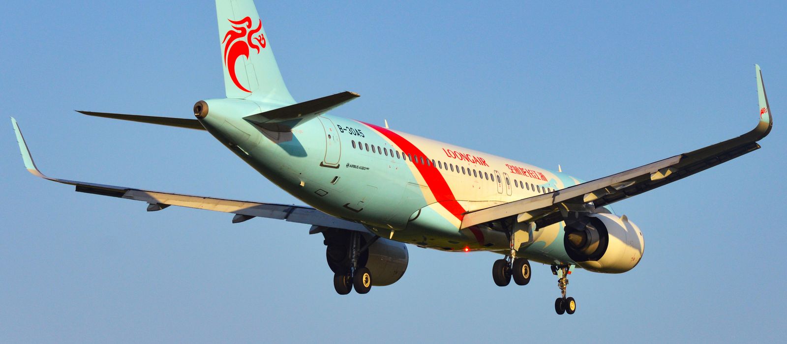 A commercial airplane descending for landing under a clear blue sky in Ningbo, China. — flights from Hong Kong to Ningbo