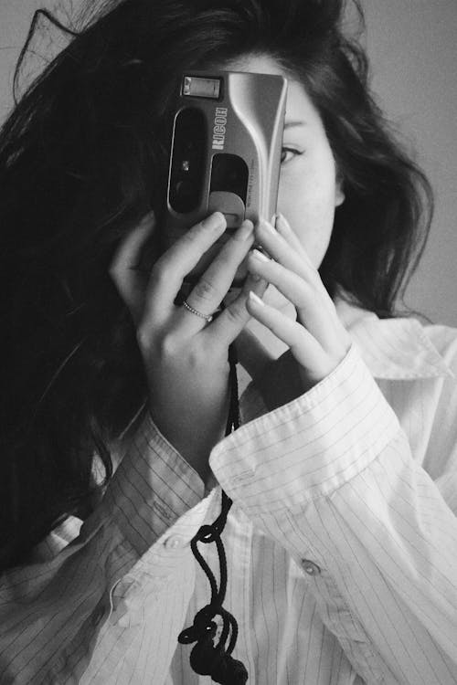 Free Grayscale Photo of a Woman Holding a Camera Stock Photo