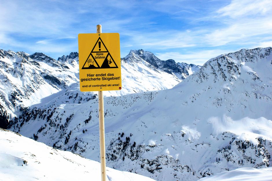 Snowy mountain landscape with a ski boundary warning sign at Sankt Anton am Arlberg, Tirol.