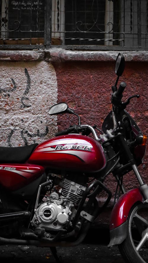 Red and Black Motorcycle Near Brown Wall