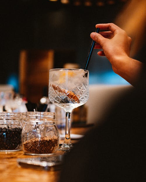 Person Putting a Drinking Straw in a Drink