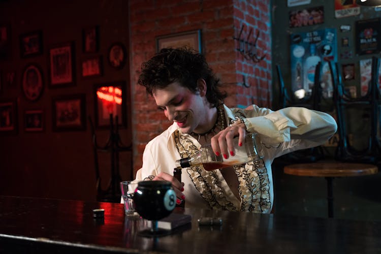 A Man Pouring Whiskey Into Bottle