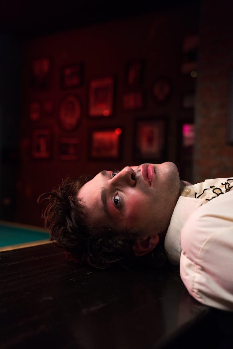 Close-Up Shot Of A Man Lying On Wooden Surface