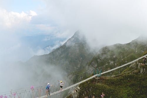 People Walking on Hanging Bridge in the Mountain