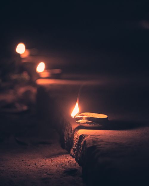 Free Peaceful evening scene with traditional Indian diya lamps glowing in the dark, symbolizing celebration and spirituality. Stock Photo