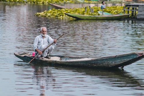 Free Photo of an Elderly Man Using a Paddle to Row a Boat Stock Photo