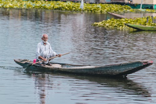 Free Photograph of an Elderly Man on a Rowboat Stock Photo