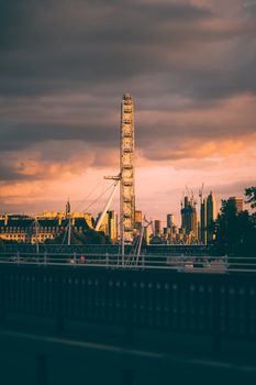 Stunning shot of the London Eye with a dramatic sunset sky and skyline backdrop.
