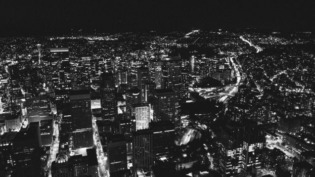 Aerial view of Seattle's vibrant nighttime cityscape illuminated in black and white.