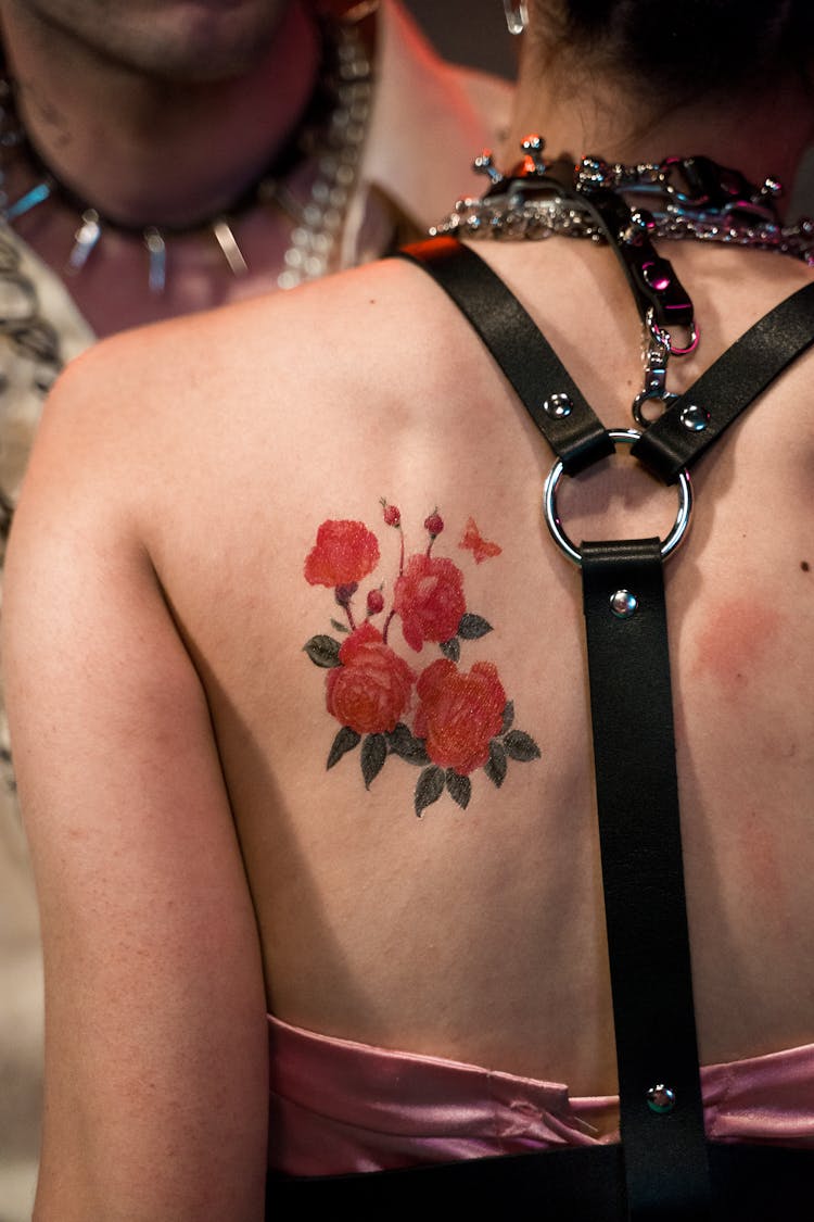 A Person With A Rose Tattoo At The Back