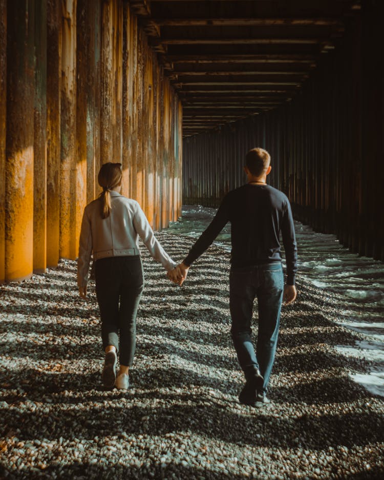 Couple Walking Under A Jetty