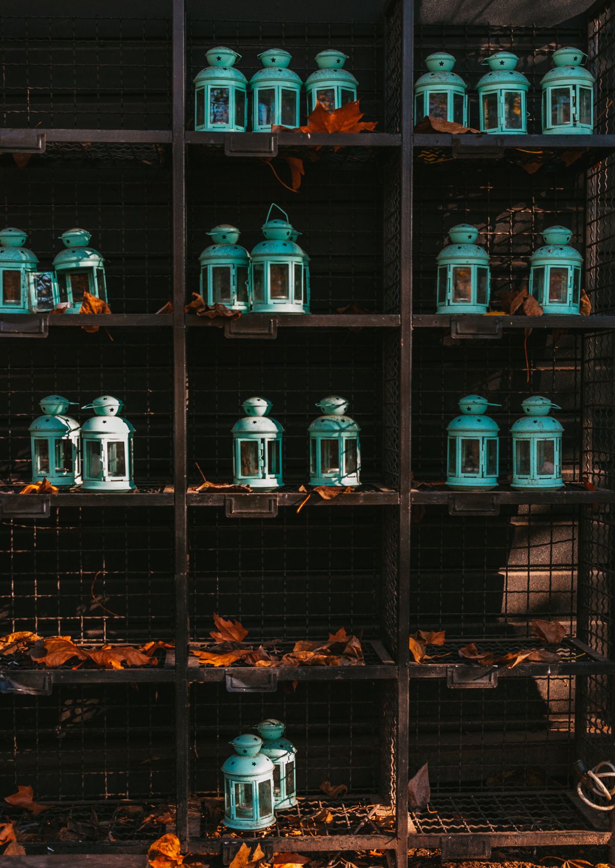 Lanterns on a shelf with dried autumn leaves