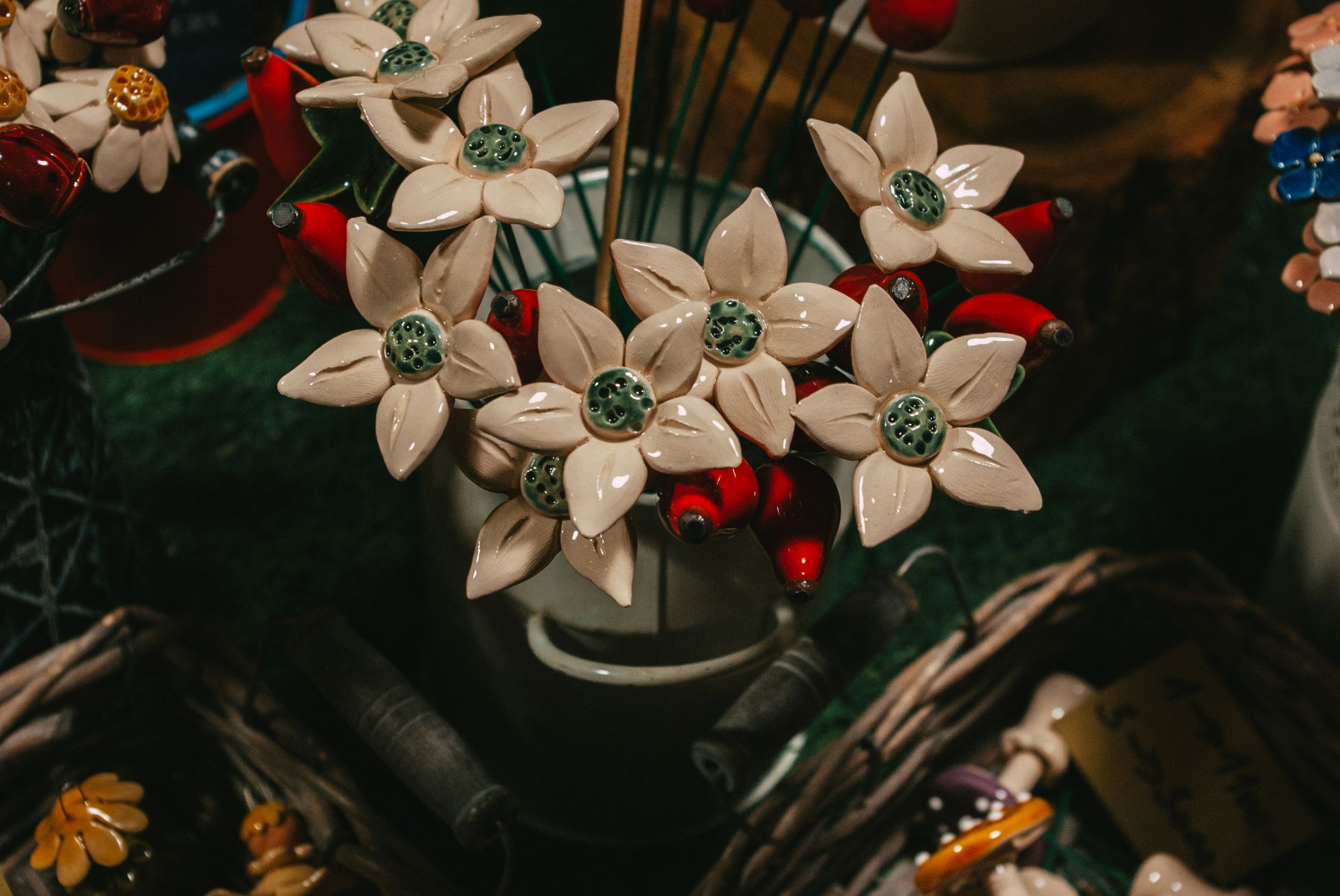 Artful arrangement of handmade ceramic flowers in a rustic vase on display.