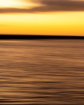 Experience the calm of a golden sunset over the ocean in Rio de Janeiro, Brazil.
