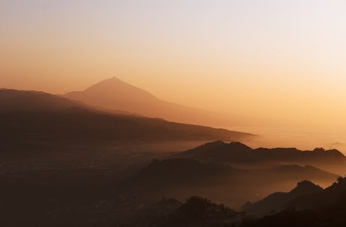 Fog over Hills on Sea Shore at Sunset