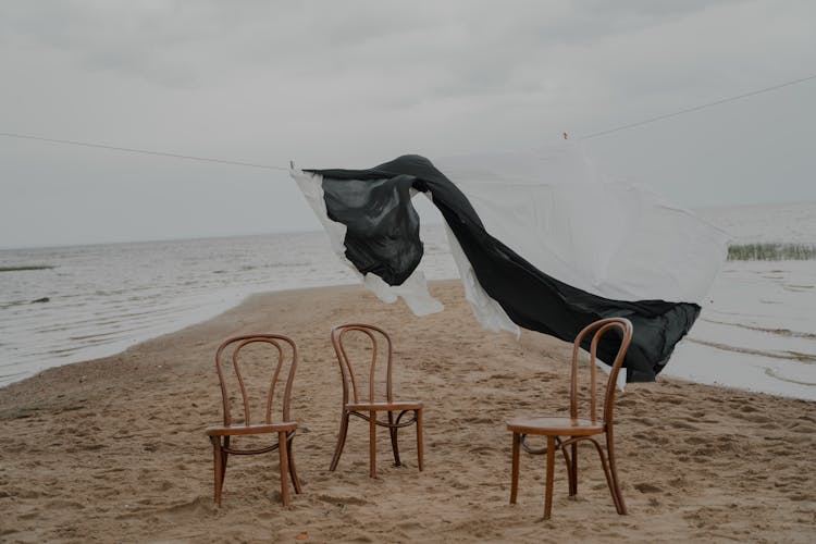 Laundry Hanging Above Chairs On Beach Shore