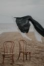 Laundry Hanging Above Chairs on Beach Shore