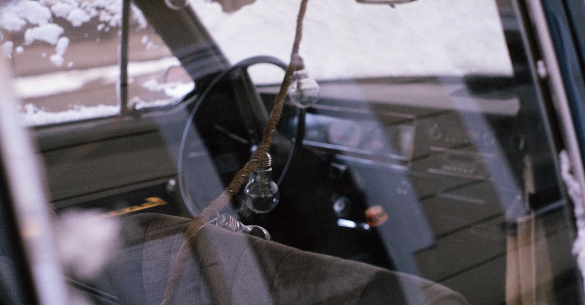 Retro car interior with hanging rope and lightbulbs in snowy setting, St. Petersburg.