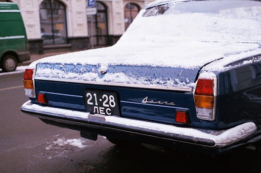 Close-up view of a vintage car's snow-covered tail, captured in an urban environment of Saint Petersburg.