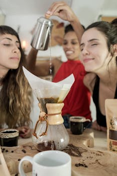 Three women enjoying a pour-over coffee experience, sharing smiles and aromas in São Paulo.