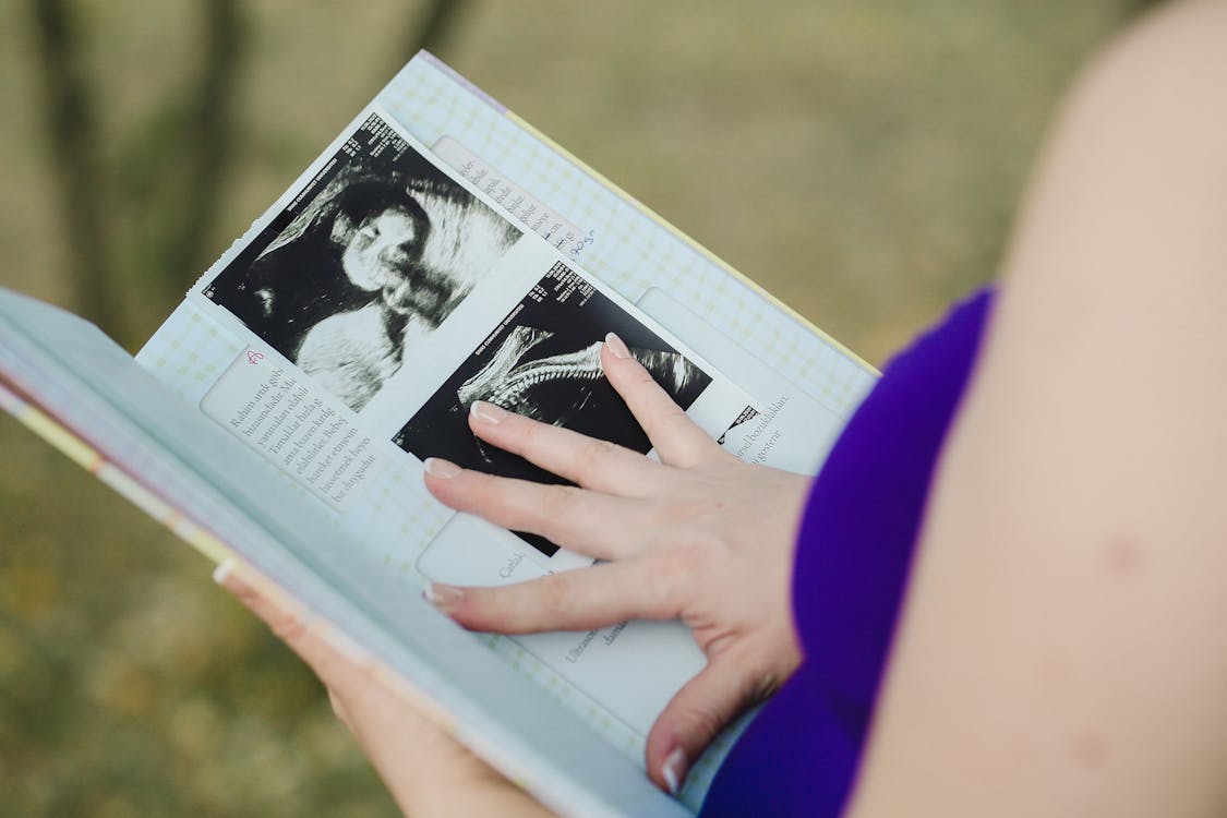 https://images.pexels.com/photos/10181939/pexels-photo-10181939.jpeg?auto=compress&cs=tinysrgb&w=1260&h=750&dpr=1 A woman’s hand of a pregnancy journal’s page
