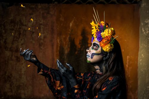 Free A woman with intricate Dia de los Muertos makeup and flower crown in a vibrant cultural setting. Stock Photo