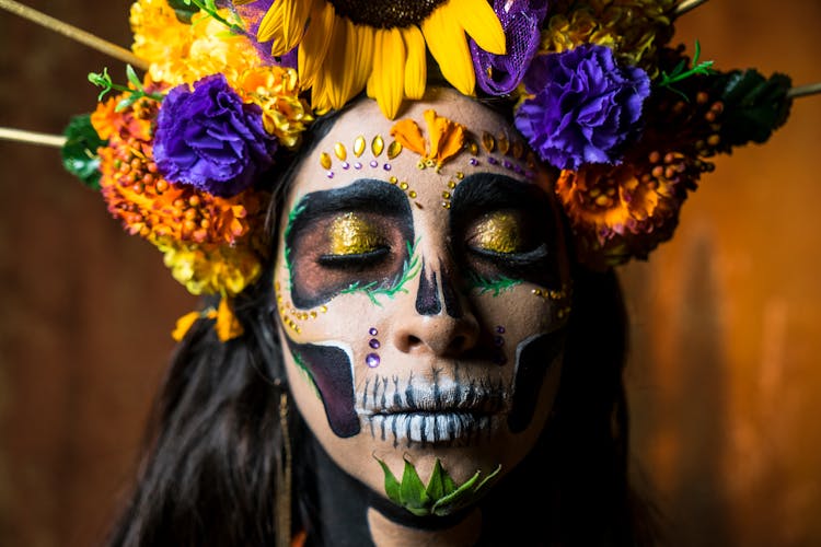 Woman With Flowers And Face Paint For Day Of Dead In Mexico