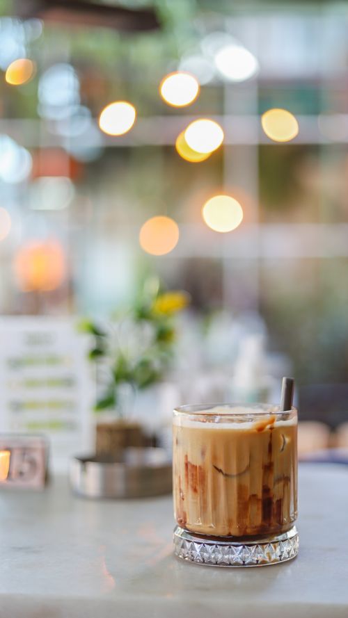 Free Delicious iced coffee on a cafe table with a beautiful bokeh background, perfect for a relaxing moment. Stock Photo