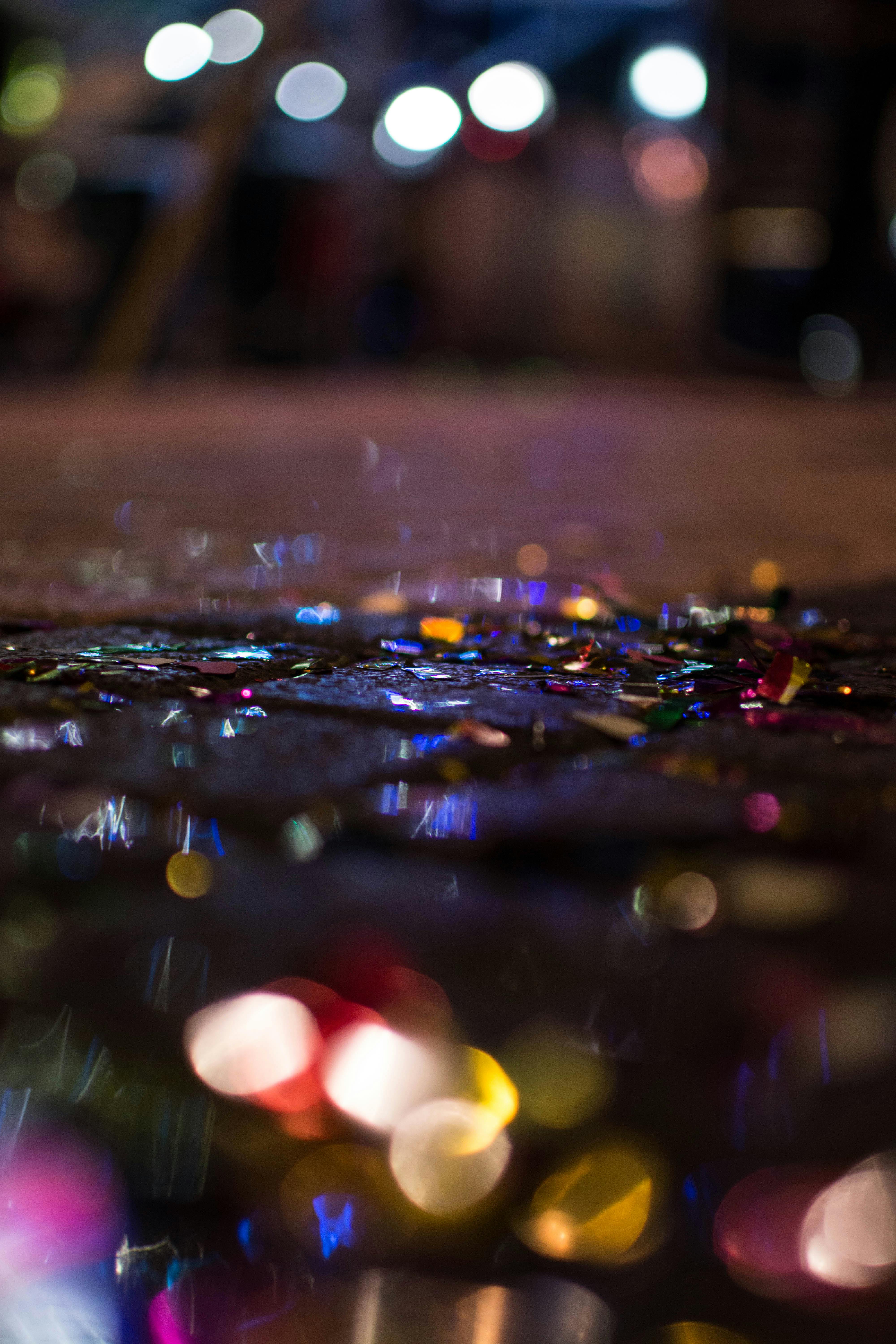 Colorful confetti sparkling in low light on a wet street in Rethymno, Greece.