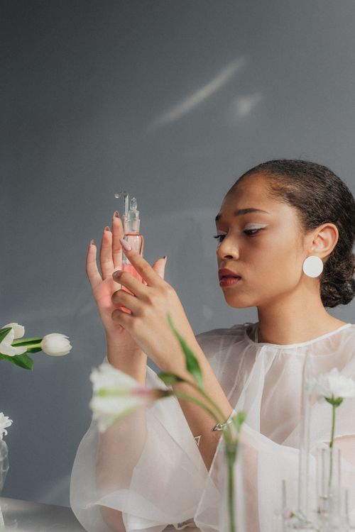 Free Sophisticated woman handling a glass flask, emphasizing science and elegance. Stock Photo