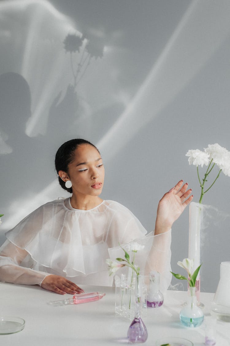 Portrait Of Woman Sitting And Looking At Plant