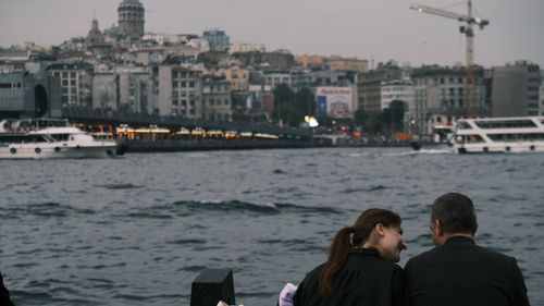 Free A couple enjoying a romantic moment by the Bosphorus in Istanbul with cityscape background. Stock Photo