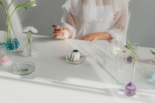 Unrecognizable Woman Sitting at Table after Chemical Experiment