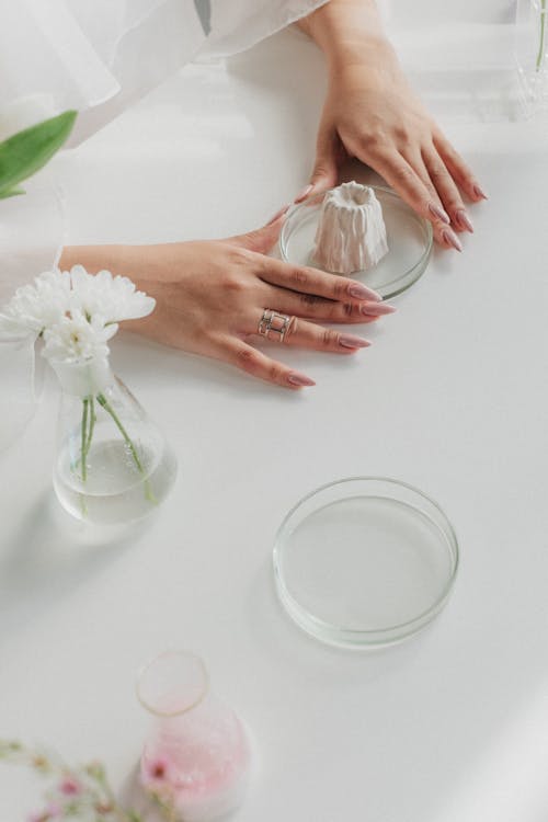 Unrecognizable Female Hands Preparing Chemical Reaction on White Table