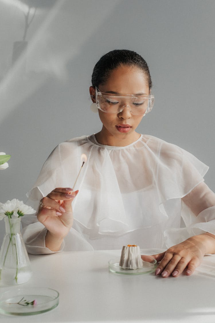 Female Scientist With Lit Match In Hand Preparing For Experiment