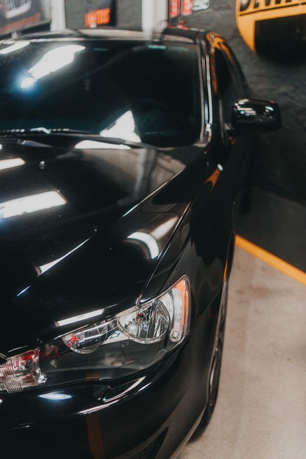 A shiny black car with a clean, glossy finish in a garage