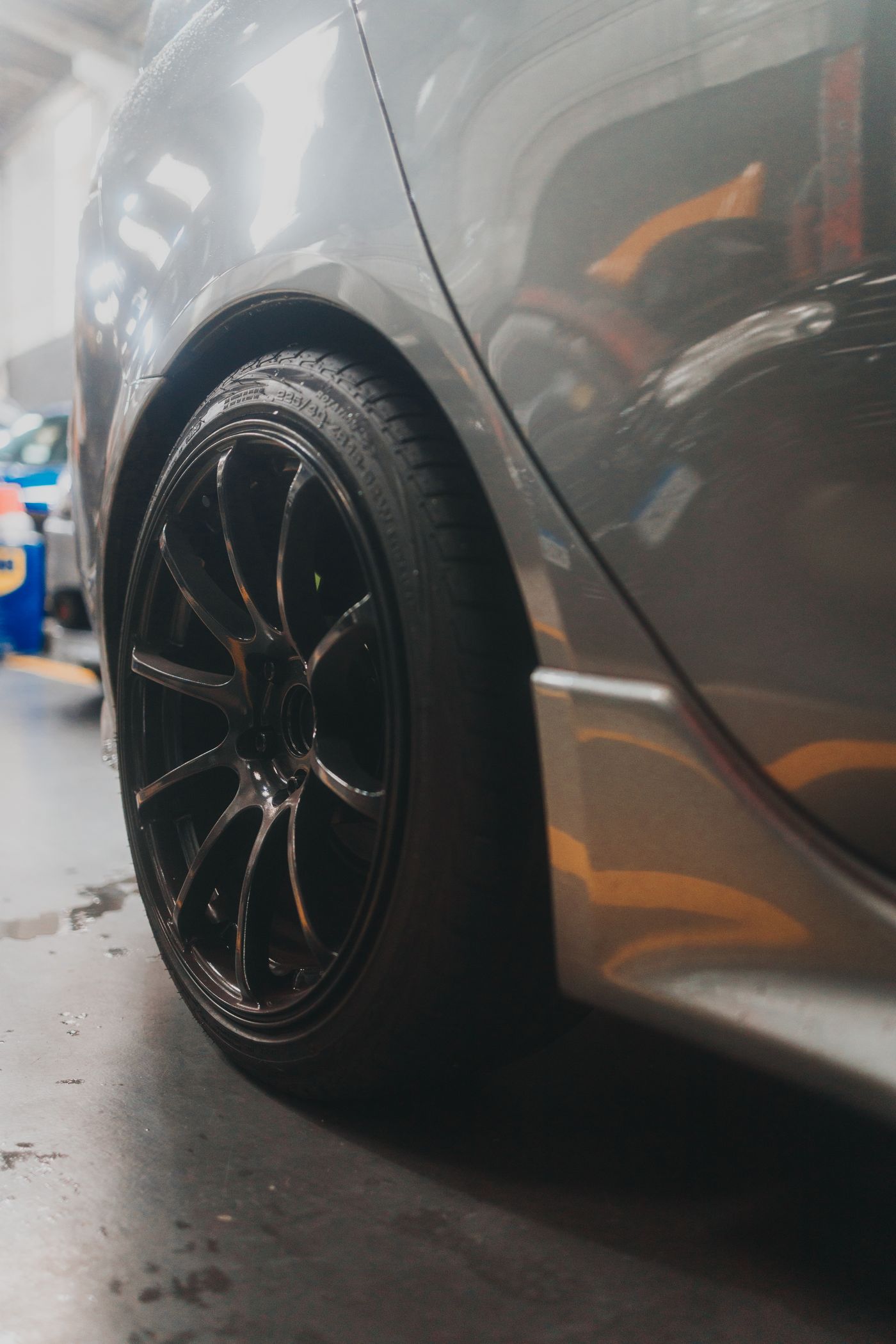 Black alloy wheel and tire on a car inside a garage