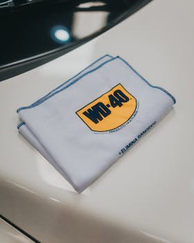 Close-up view of a WD-40 branded cloth on a glossy white surface, ideal for cleaning themes.