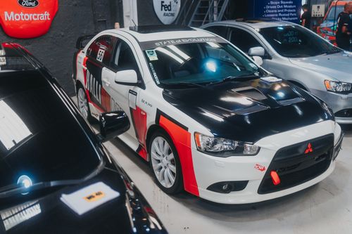 Free Detailed view of a customized Mitsubishi Lancer Evolution on display in a garage setting. Stock Photo