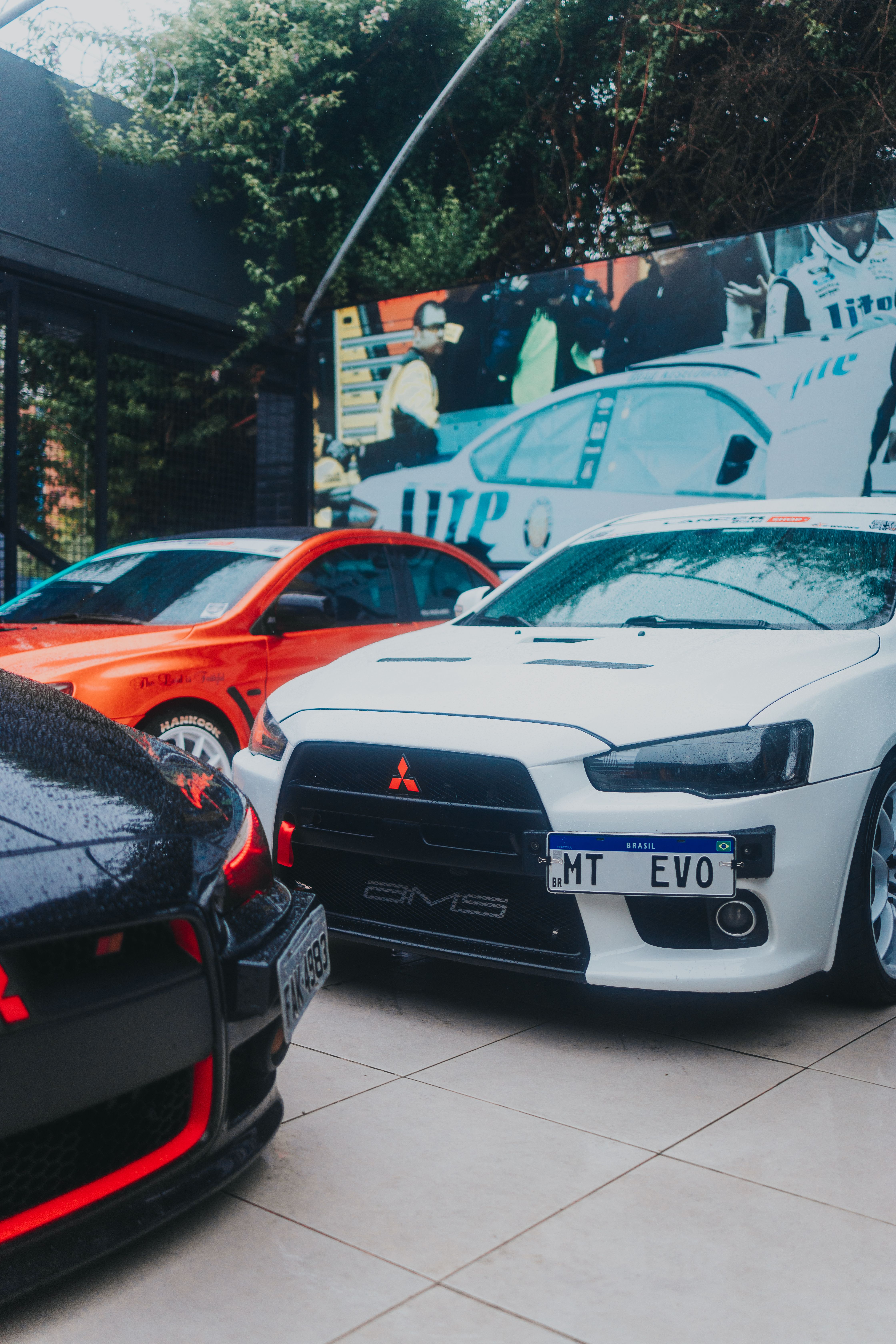 Showcase of Mitsubishi Lancer Evolution and other sports cars parked outdoors.