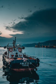 Serene scene of a fishing boat docked in a peaceful harbor at twilight, capturing the quiet beauty of the sea.