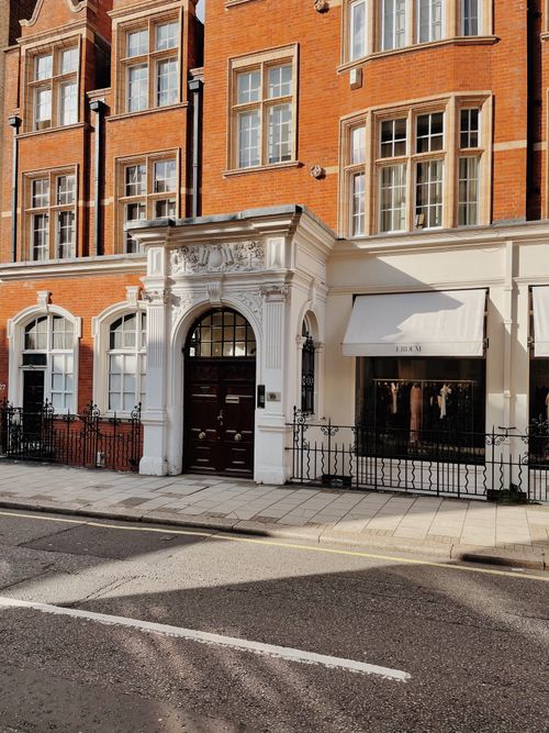 Free Charming red brick building with intricate white architectural elements on a sunny street. Stock Photo