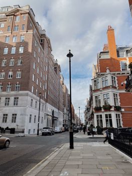 A picturesque urban street scene featuring historic red-brick buildings under a bright sky.