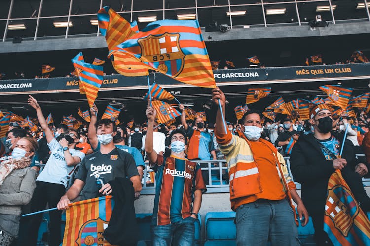 People In Face Masks Waving Flags