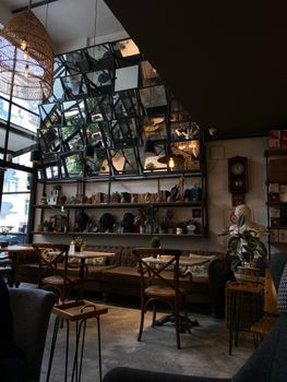 Warm and inviting cafe interior with rustic decor, mirrors, and wooden furniture, perfect for relaxation.