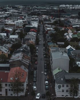 Aerial view of a bustling street in Reykjavík, Iceland, with colorful buildings and parked cars.