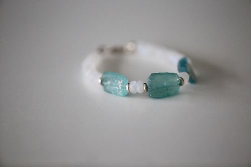 Free Close-up of a handcrafted aquamarine crystal bead bracelet on a neutral backdrop. Stock Photo