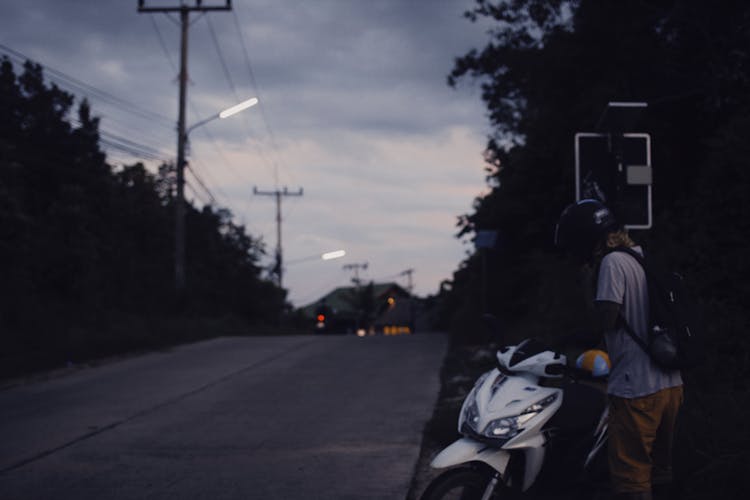 A Man With A Motorcycle At Dusk