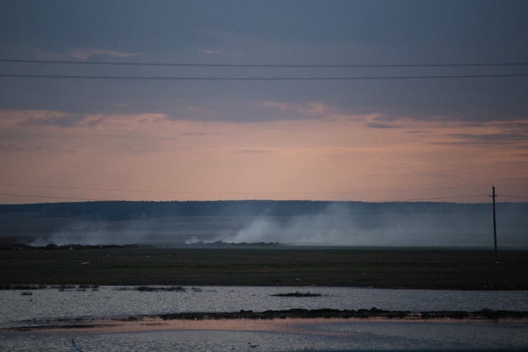 Smoke Above Plowed Field At Dusk 